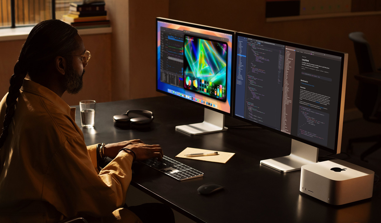 Ein Profi arbeitet mit einem Mac Studio und zwei Studio Display Monitoren