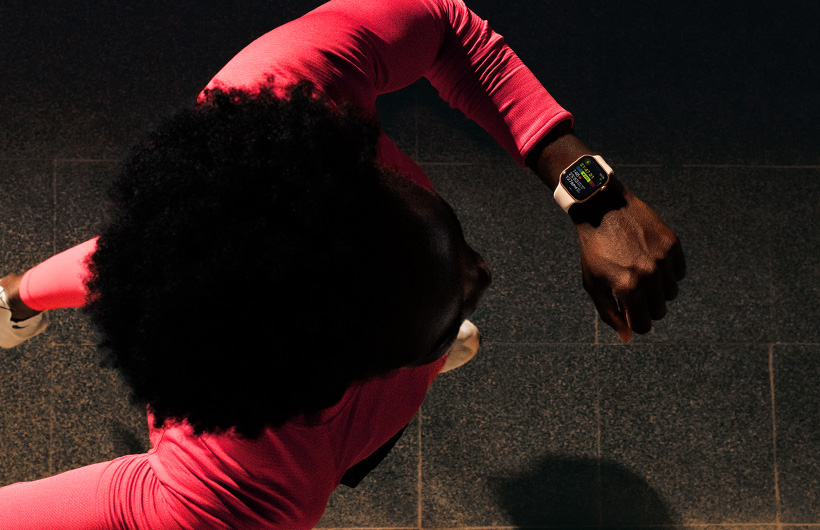 러닝을 하며 Apple Watch Series 11 운동 앱에서 진행 상황을 확인하는 사람의 모습