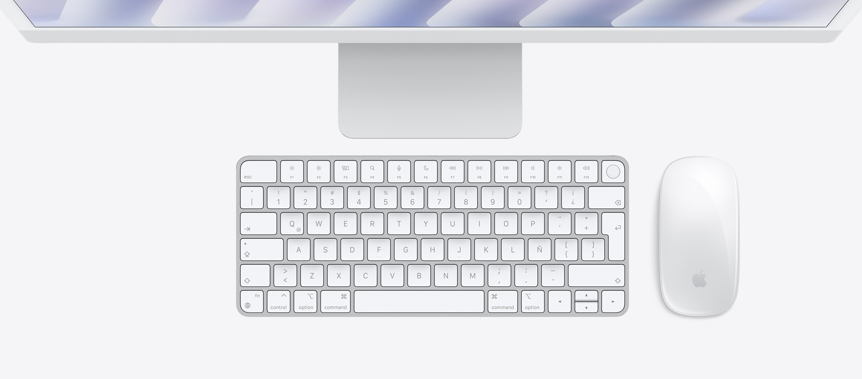 Vista panorámica de una iMac color plata con mouse y teclado a juego