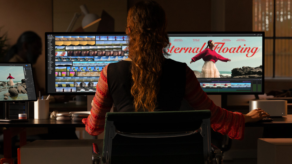 Bir çift monitörün önünde oturan bir kişinin arkadan görünümü. Monitörlerin ekranında bir video içeriğinin kurgusu yapılıyor.