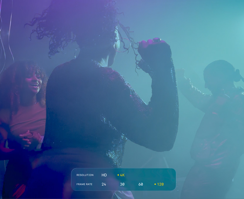 Un écran affichant des personnes en train de danser dans l’obscurité illustre les capacités du format Dolby Vision 4K à 120 i/s