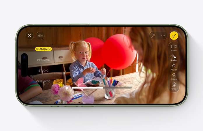 iPhone 17, przód urządzenia, nagranie wideo z włączoną funkcją Miks audio, dziecko bawi się balonikami przy stole